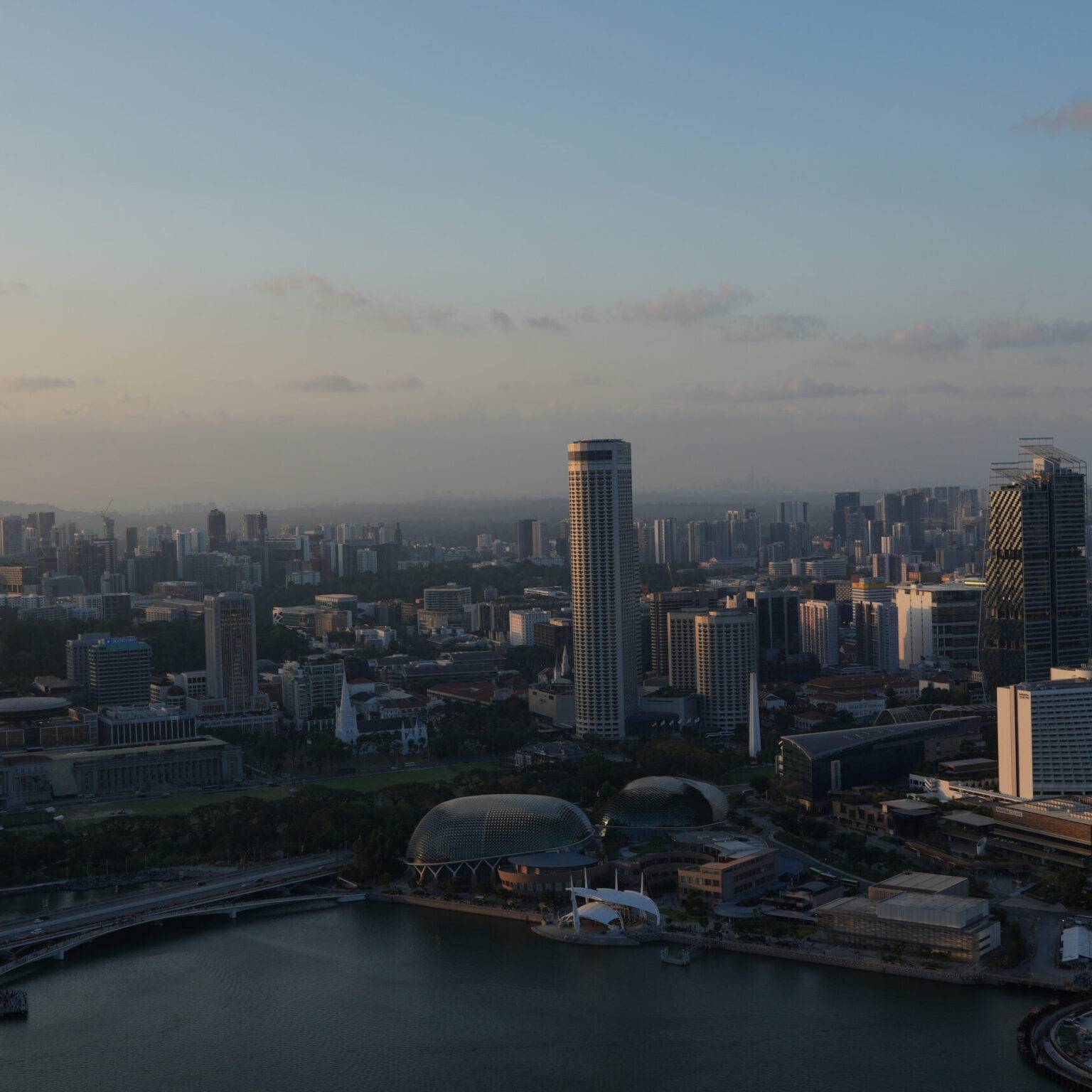 Skyline von Singapur bei Sonnenuntergang, aus großer Höhe fotografiert.