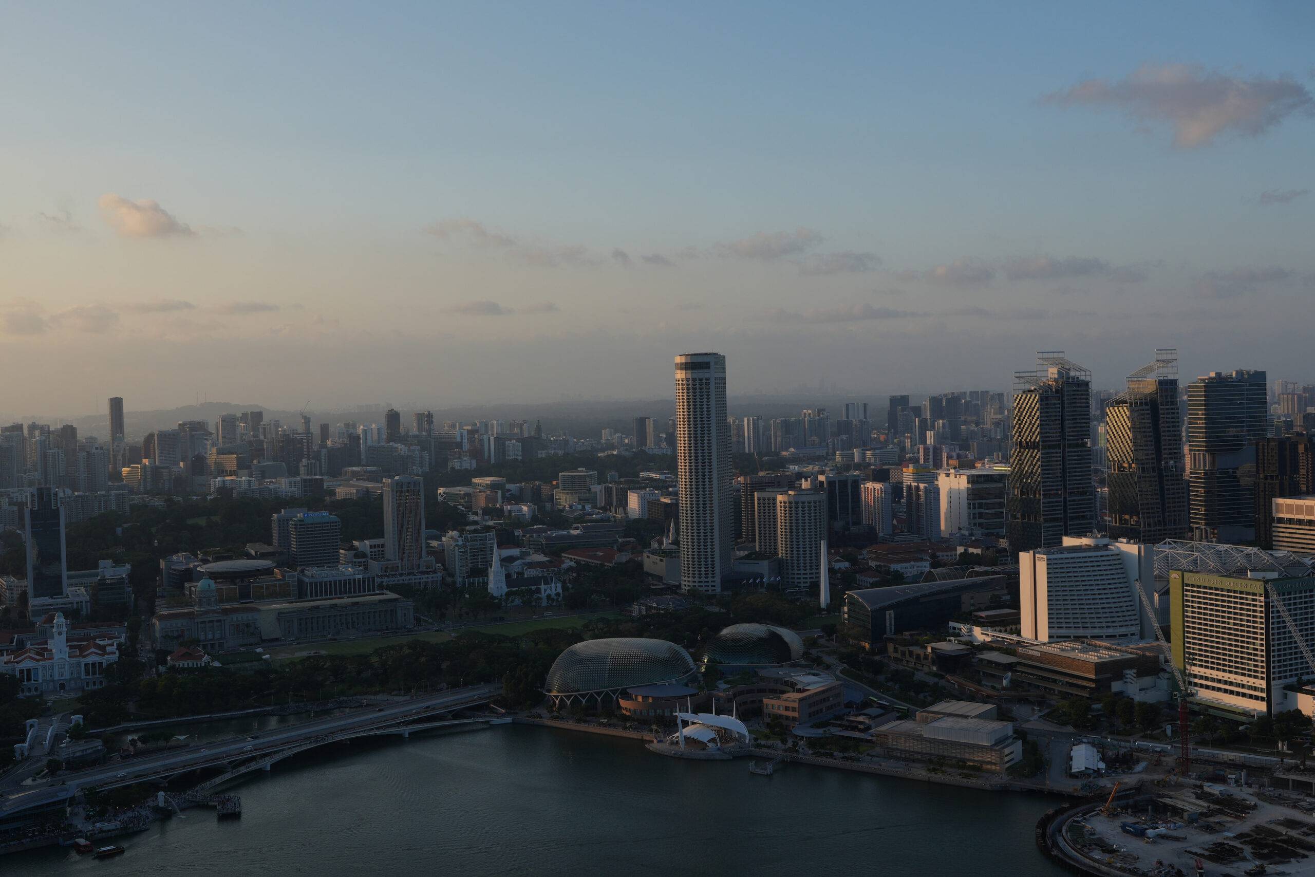 Skyline von Singapur bei Sonnenuntergang, aus großer Höhe fotografiert.