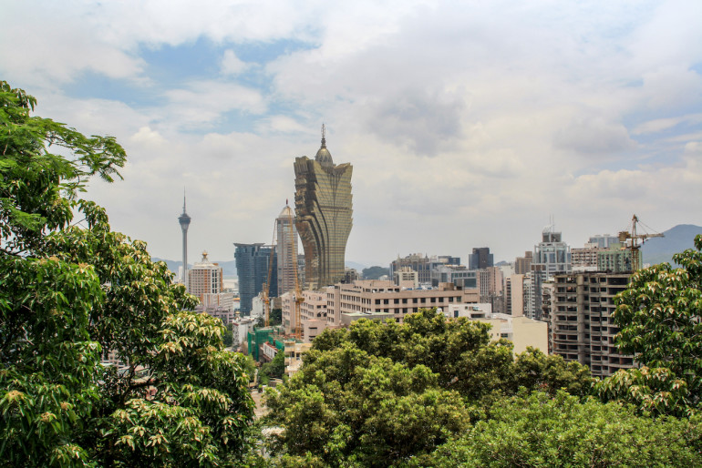 Ausgefallene Wolkenkratzer ragen zwischen Bäumen und Gebäuden dem Himmel empor in Macau, China.