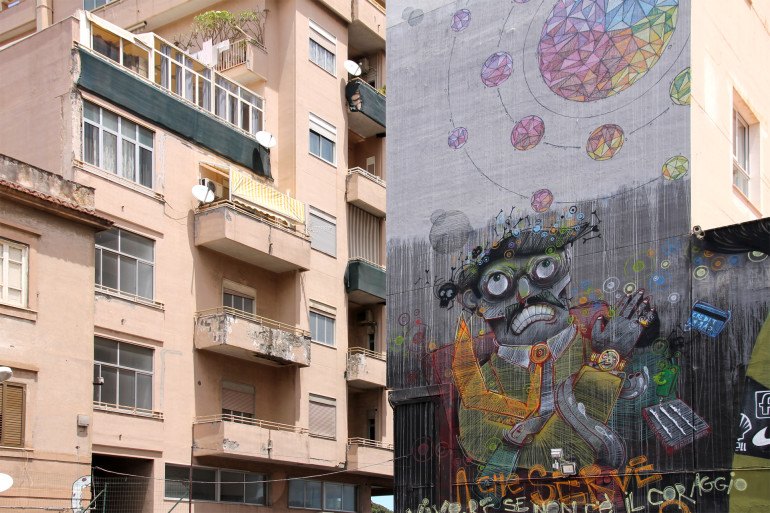 An einer Hausfassade neben einem Wohngebäude in Palermos Innenstadt wurde ein Roboter in Street Art gemalt.