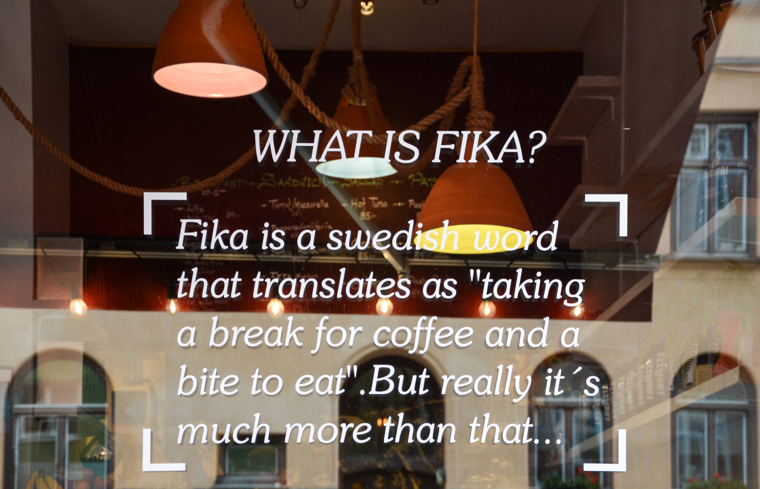 Das Fenster eines Stockholmer Cafés ziert ein Aufkleber, der beschreibt, was es mit der schwedischen Kaffeepause namens "Fika" auf sich hat.