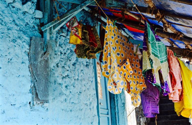 An einer hellblauen Hausfassade in Malabar Hill, Bangaga Tank hängt Wäsche an Leinen.