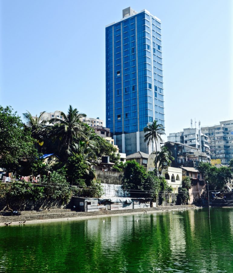 In Mumbais Malabar Hill am Banganga Tank treffen Wolkenkratzer auf alte Tempel und begrünte Ruhe-Oasen am Wasser.