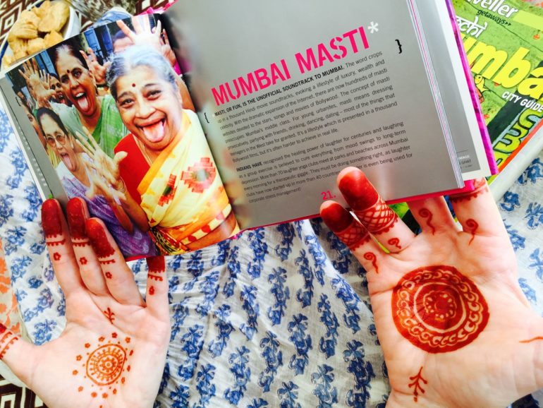 Zwei mit Henna bemalte Frauenhände halten das Buch Mumbai Masti in die Kamera.