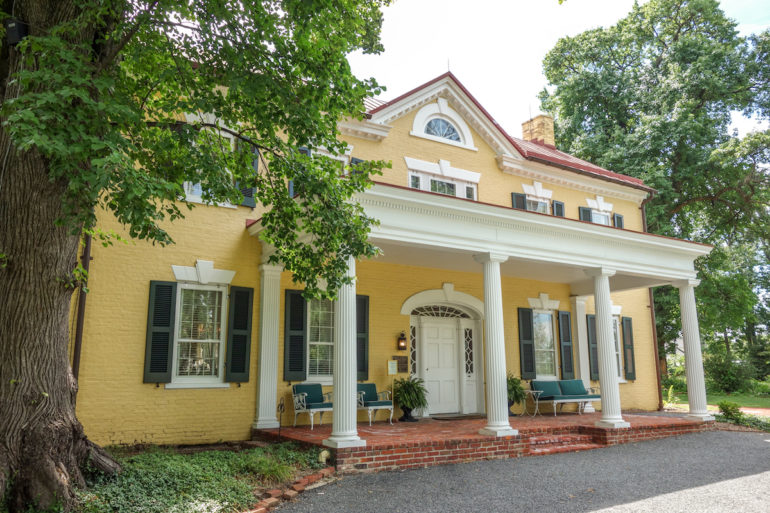 Das Marshall House in Virginia ist im typischen Südstaaten-Stil gehalten, weiße Säulen schmücken den Eingangsbereich der gelben Villa mit ihren grünen Fensterläden, eingebettet von großgewachsenen Bäumen.