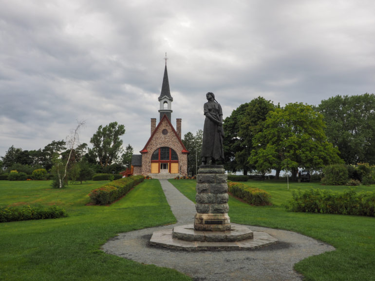 Im Grand Pré National Historic Site steht in einer parkähnlichen Anlage eine Statue und eine kleine Steinkirche mit Spitzturm.
