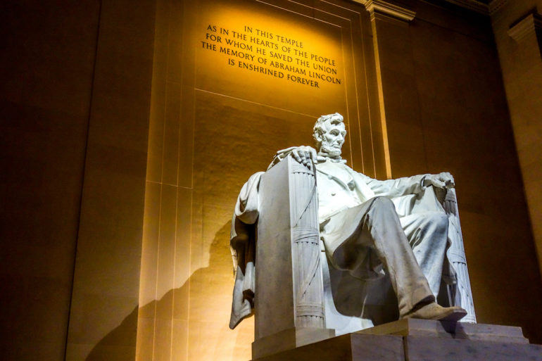 In Washington D. C., USA thront Abraham Lincoln in weißem Stein gefasst auf einem Thron aus Büchern über ihm ist der Spruch: "IN THIS TEMPLE AS IN THE HEARTS OF THE PEOPLE FOR WHOM HE SAVED THE UNION THE MEMORY OF ABRAHAM LINCOLN IS ENSHRINED FOREVER" beleuchtet.