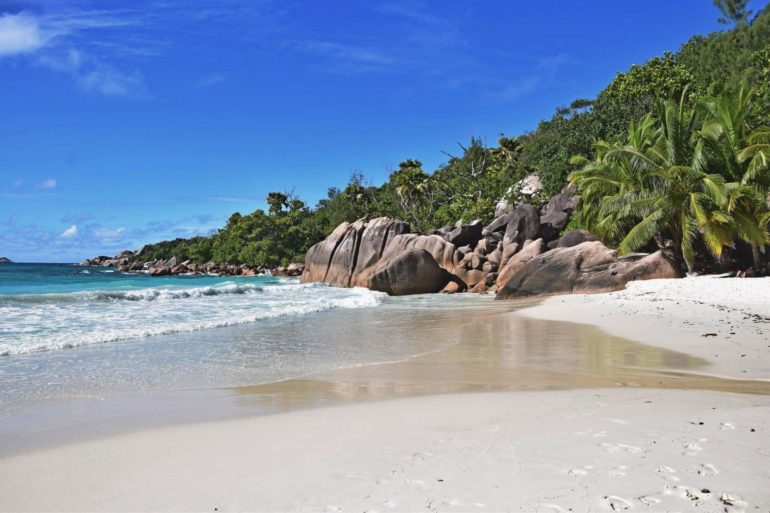 The waves wash the sea water onto the beach of Anse Lazio in the Seychelles.
