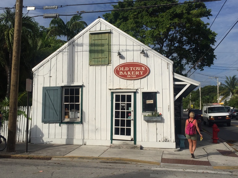 Die Old Town Bakery an einer Straßenecke in Key West befindet sich in einem kleinen weißen Holzhäuschen mit blauen Fensterläden.
