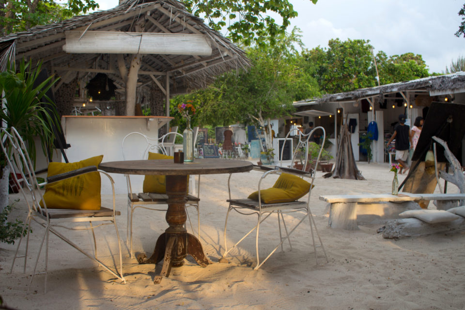 Auf der Insel Gili Trawang lässt es sich an der Strandbar Casa Vintage Beach an einer gemütlichen Sitzecke mit Holztisch hervorragend entspannen.