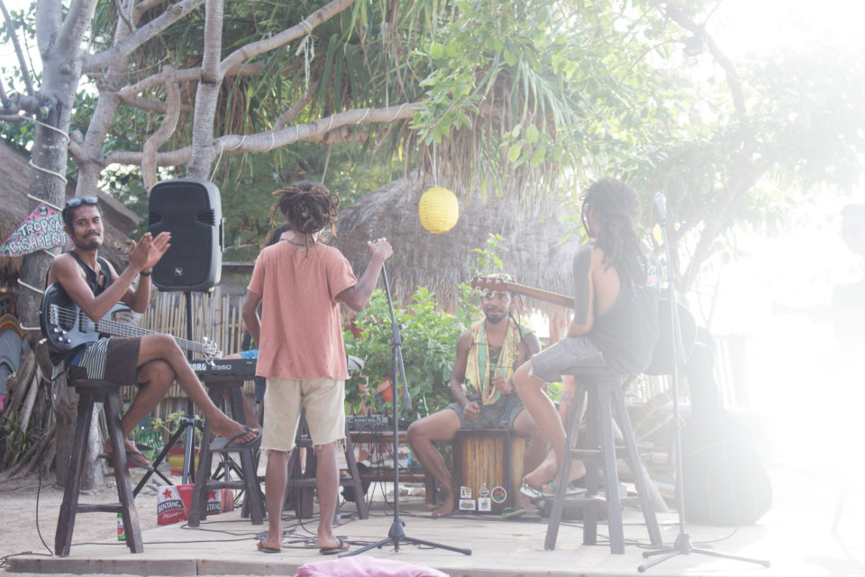Einheimische Musiker geben vor einer Strandhütte auf der Gili Insel Gili Air ein Open Air Konzert.
