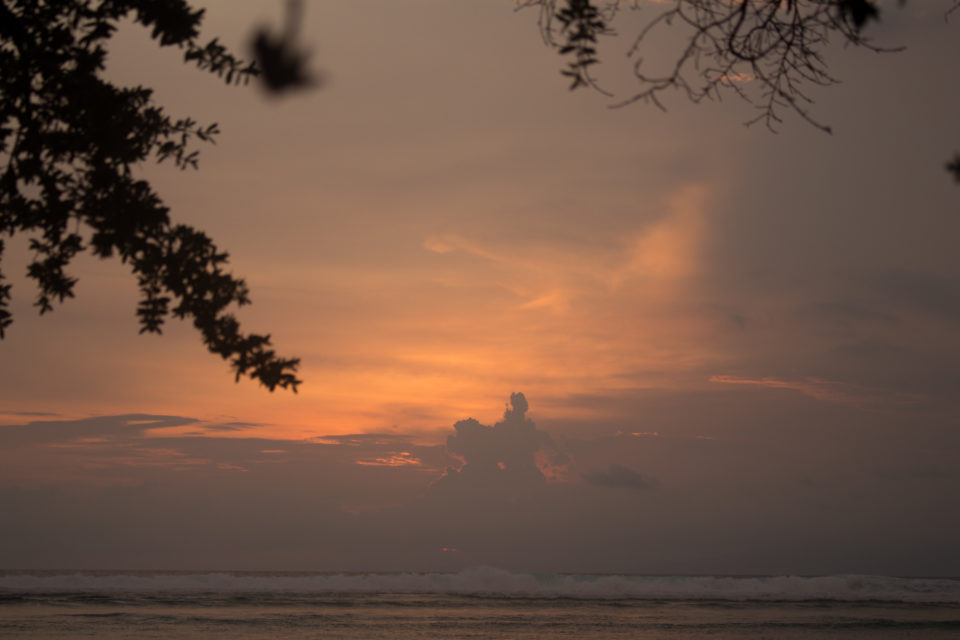 Der Sonnenuntergang am Strand von Gili Meno der indonesischen Gili Insel taucht den Horizont in rot-blaue Pastelltöne.