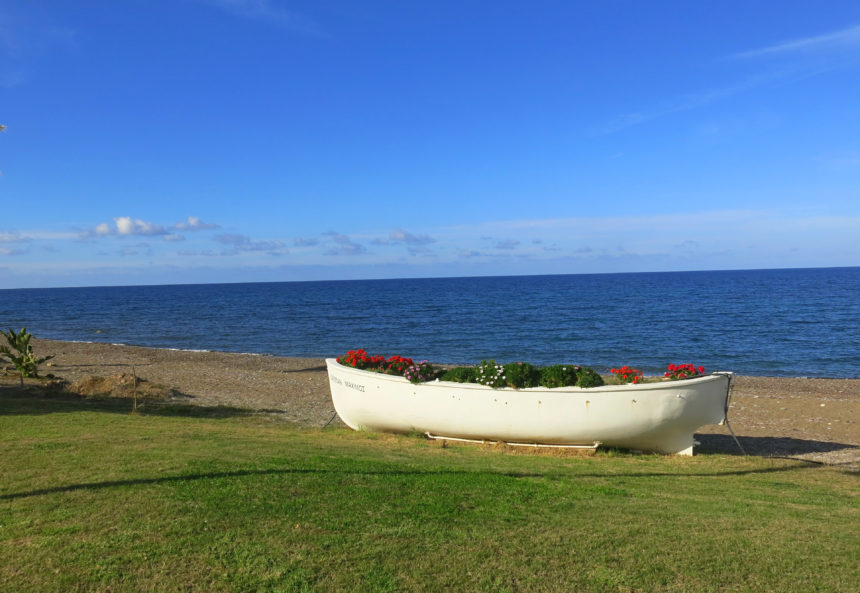 Den Strand bei Latsi in der Nähe von Paphos auf Zypern schmückt ein altes blumengeschmücktes Boot.