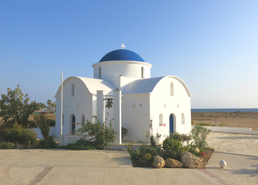 Eine blau-weiße orthodoxe Kapelle steht vor dem Strand von Paphos im Westen Zyperns.