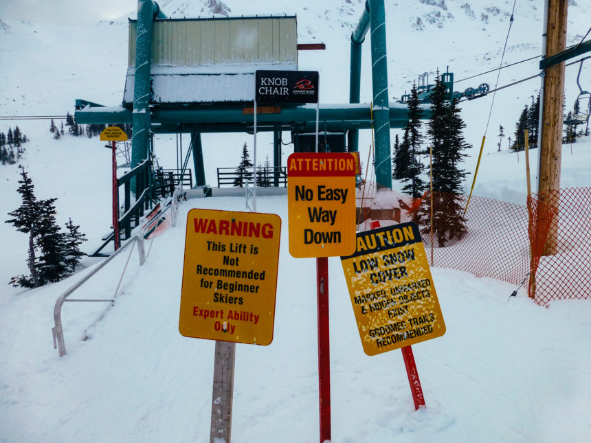 Gelbe Warnschilder auf einer kanadischen Skipiste warnen Skianfänger vor der schwierigen Abfahrt.