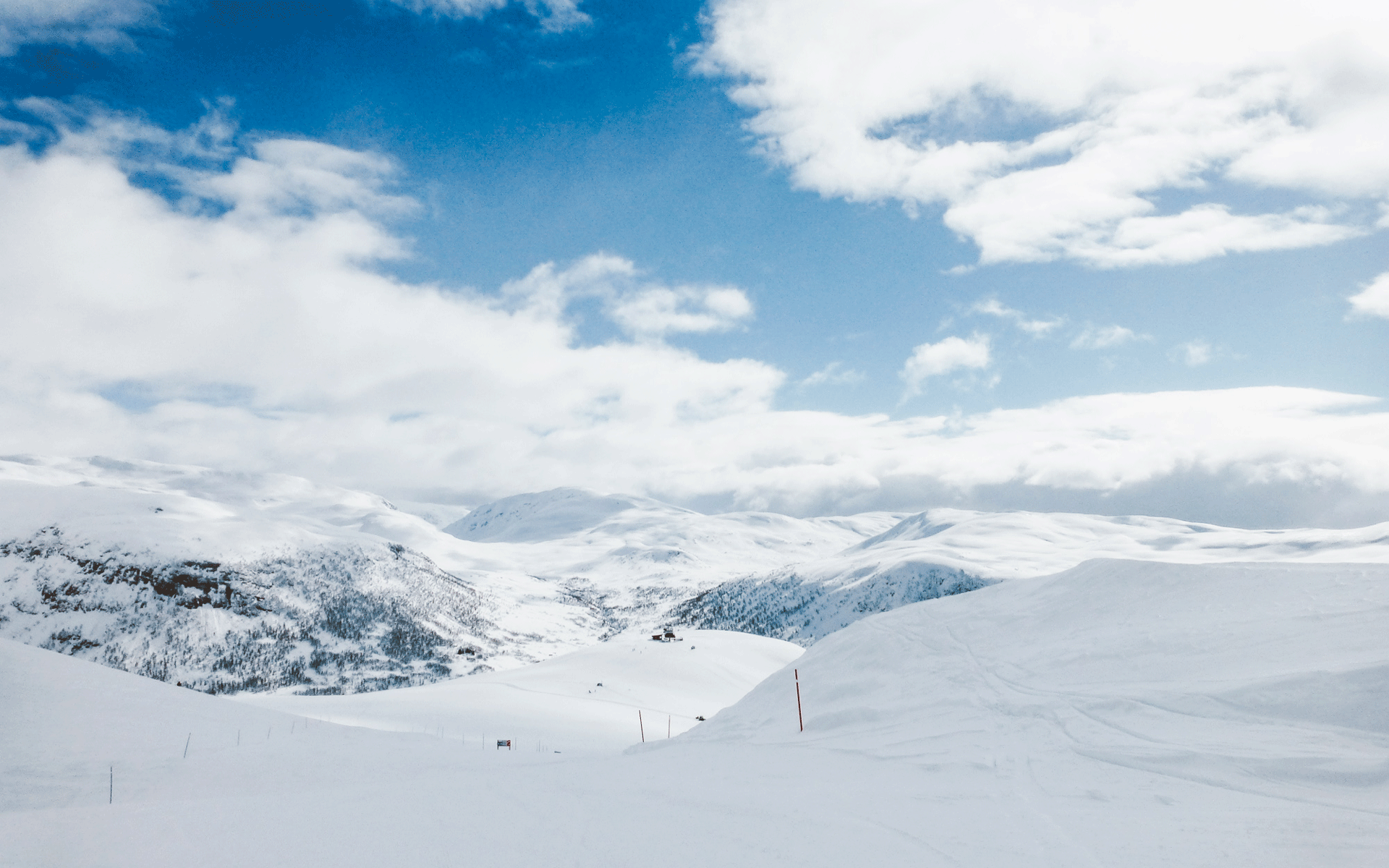 Die schneebedeckten Skiberge in Myrkdalen, Norwegen sind flach abfallend und verschmelzen im Anblick mit den Wolken am Himmel.