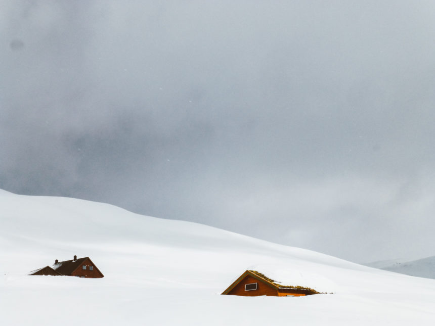 Inmitten eines Berges in Norwegen, Myrkdalen, stehen zwei Hütten, die eingeschneit wurden.