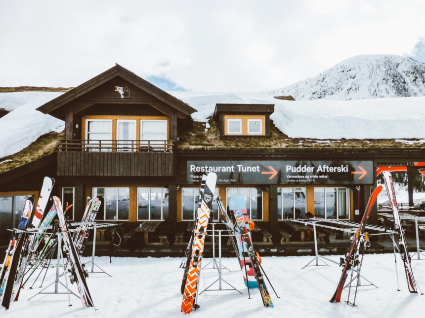 Vor einer Holzhütte in einem Skigebiet in Norwegen, haben die Gäste ihre Skiutensilien abgestellt.