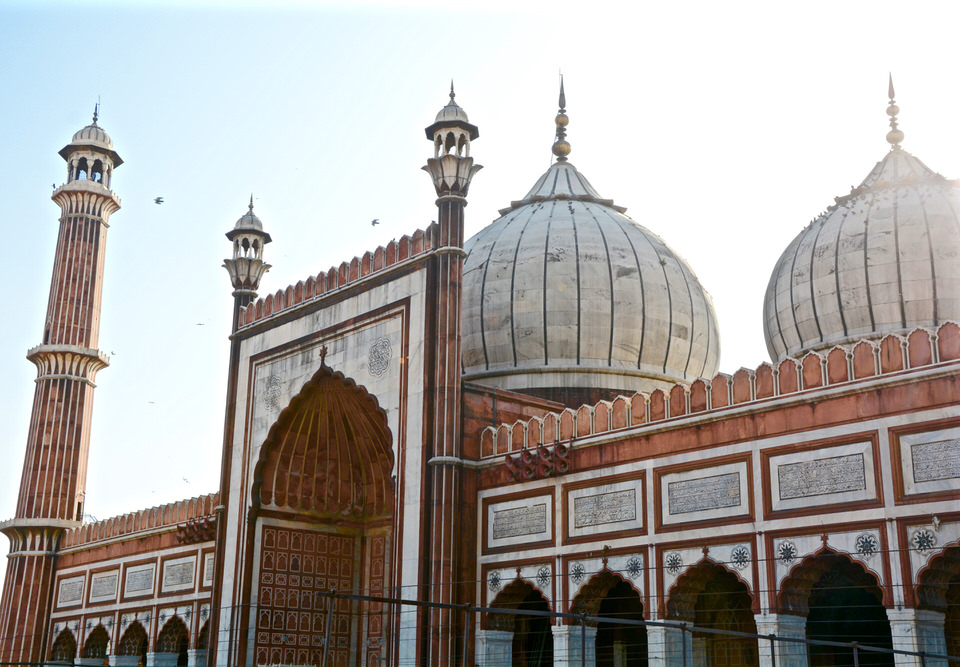 Der Eingangsbereich der größten indischen Moschee Jama Masjid in Delhi besticht durch braune Mosaikmuster und kugelförmige Türmchen.