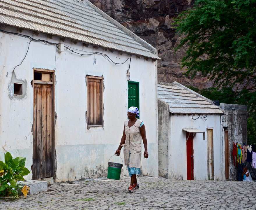 In dem beschaulichen kleinen Bergdorf Chã de Igreja auf den Kapverden trägt eine einheimische Frau gemütlich einen Eimer ihres Weges.