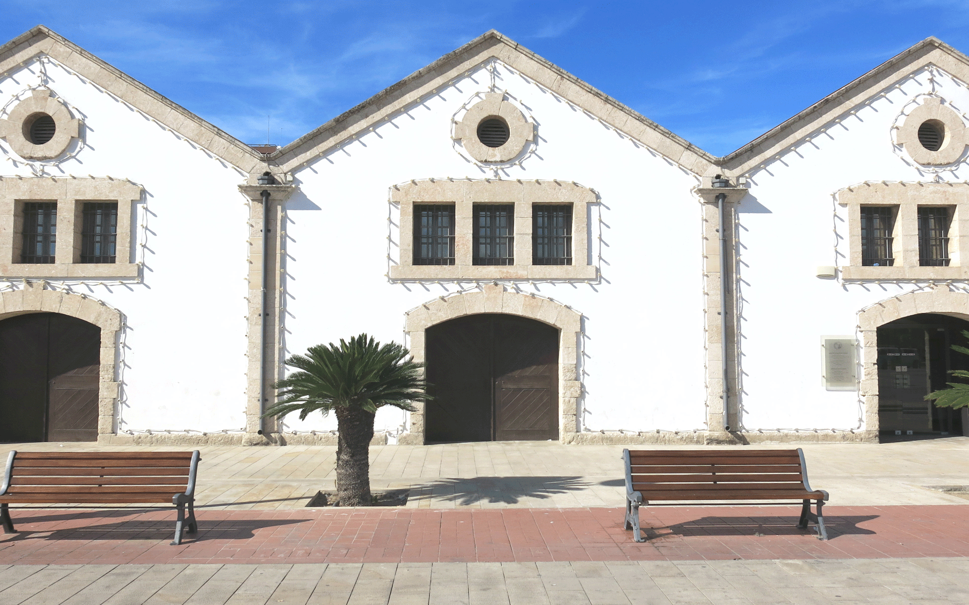 Die Häuschen des Kulturzentrums in Larnaka, Zypern sind im Kolonialstil in weiß gehalten, die in Steinen gefassten Fenster und Tore sind mit Lichterketten eingerahmt.