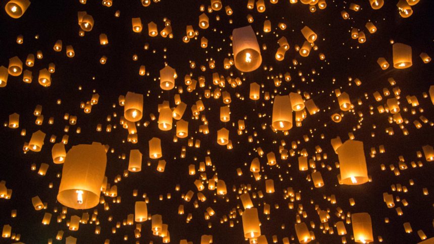 Zu Thailands Lichterfest Loy Krathong steigen Hunderte von Laternen in den schwarzen Nachthimmel empor.