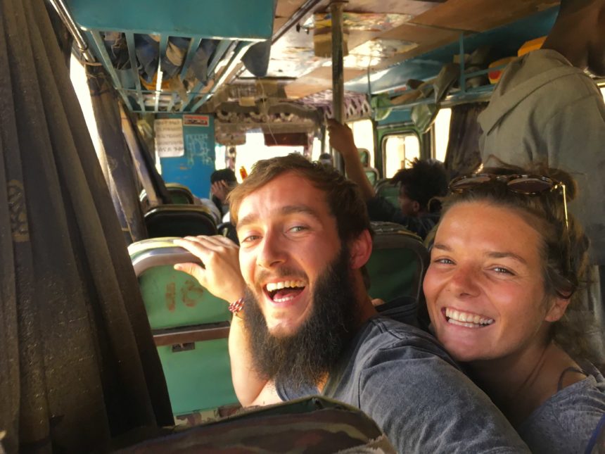 Das Bloggerpärchen Anne und Clemens sitzen in einem Bus und strahlen in die Kamera, sie haben ihre Weltreise gut organisiert.