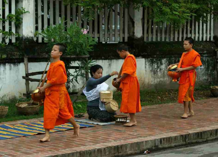 Drei junge buddhistische Mönche sammeln Spenden auf der Straße um sich von Geld Essen kaufen zu können.