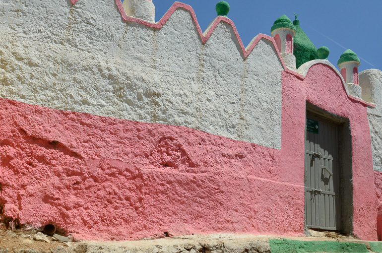 Die gewellte Fassade einer Moschee in den Farben weiß und rosa und grünen Türmchen in Harar, Äthopien.