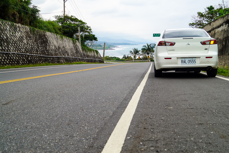 Eine Straße entlang der taiwanesischen Küste führt die Blogger mit ihrem weißen Mitsubishi Lancer auf ihren Roadtrip.