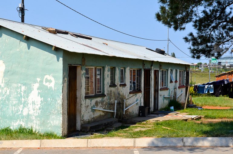 Ein Häuschen mit Wellblechdach und bröckelnder Fassade in Soweto, Johannesburg.