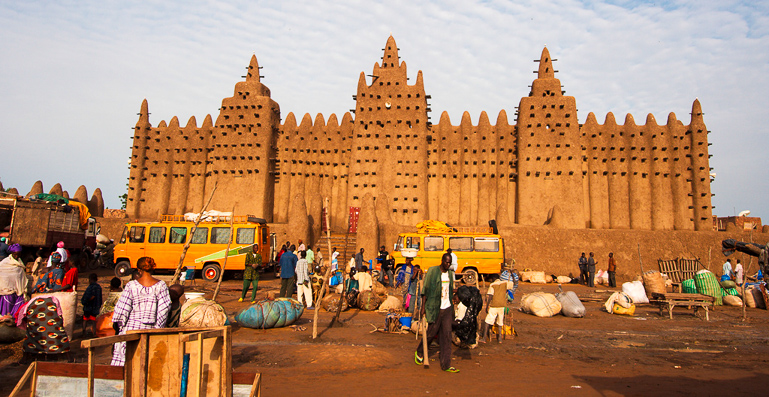 Vor der in Lehm und in sudanesischer Architektur errichteten Moschee Djenné in Mali findet ein Markt statt.