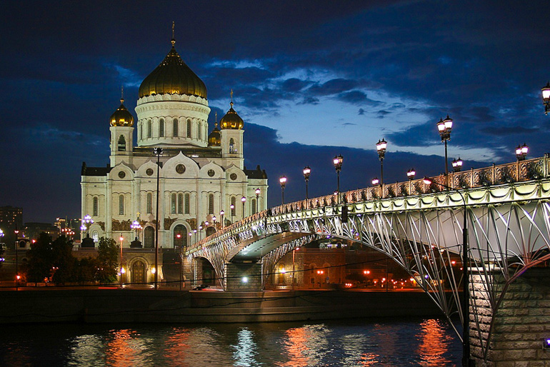 Der Weg zur russisch-orthodoxen Christi-Erlöser-Kathedrale in Moskau führt über eine Brücke, wunderschön beleuchtet bei Nacht.