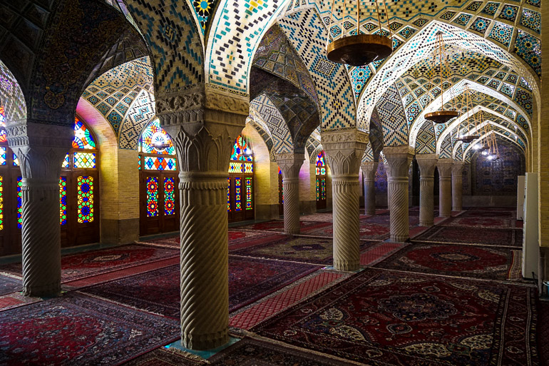 In der Nasir-al-Molk-Moschee im Iran liegen Gebetsteppiche zwischen Säulen deren Deckenbogen aufwendig mit Mosaiken verziert wurden.