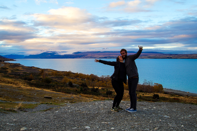 Das Bloggerpärchen Anne und Clemens küssen sich freudestrahlend vor der traumhaften Landschaft Neuseelands.