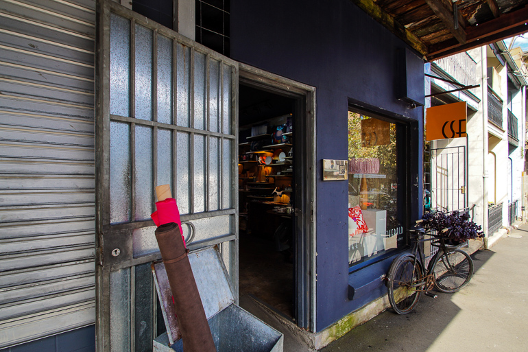 An der blaue Außenfassade des Stoffladens Chee Soon & Fitzgeral in Redfern lehnt ein altes Fahrrad, das als Werbebanner fungiert.d
