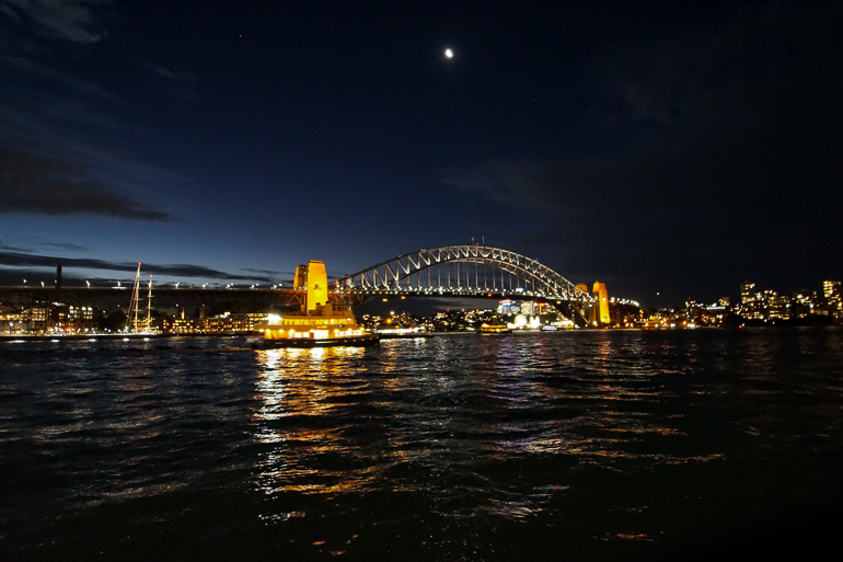 Bei Nacht ist Sydneys Harbour Bridge beleuchtet.