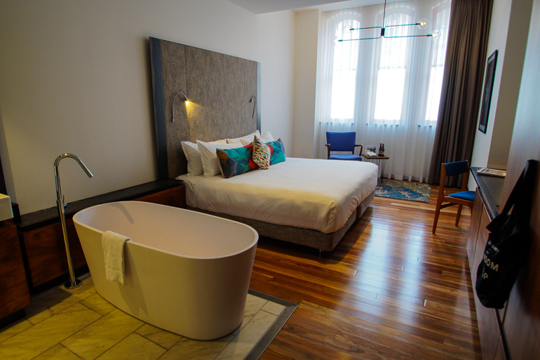 Die Zimmer des The Old Clare Hotels in Sydney, Australien verfügen über ausreichend Platz, Holzboden und freistehender Badewanne.