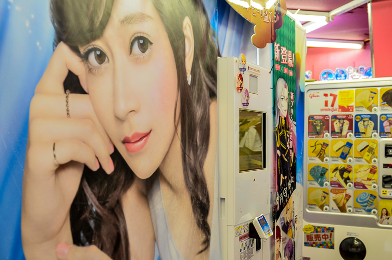 In einem der Purikura Fotoautomaten in Tokio, Japan kann man sein Passfoto in ein Mangamotiv umwandeln; an der Wand hängt ein riesiges weibliches Fotomotiv neben dem Fotoautomaten um sich inspirieren zu lassen.