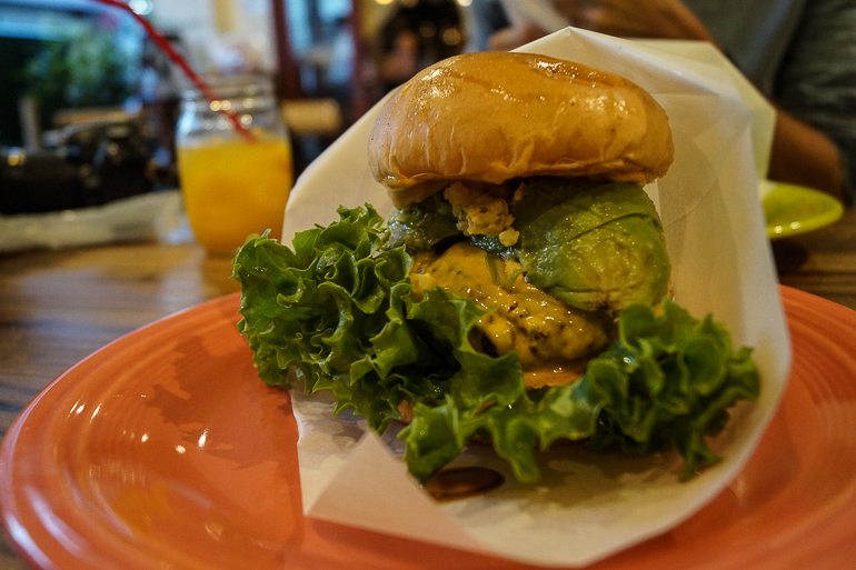 Auf der Yaeyama Insel Ishigaki in Japan wird auf einem orangen Teller in Papier gehüllt ein Burger des Restaurants Ishigaki Village serviert.