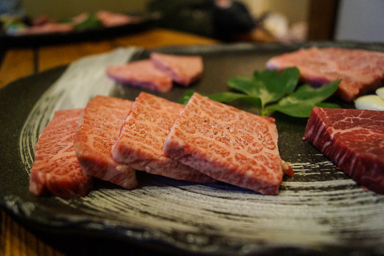 Auf einem Teller wird im japanischen Restaurant Ishigakiya auf der Yaeyama Insel Ishigaki in Scheiben rohes japanisches Rindfleisch zum Grillen angeboten.