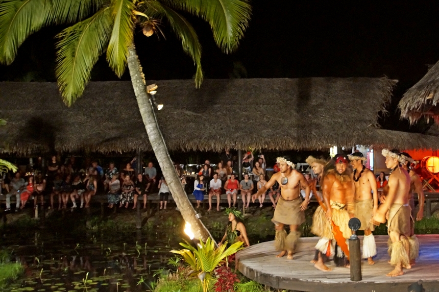 Unter Strohschindeln bedeckten Zuschauerrängen lauschen Gäste der Aufführung von Te Vara Nui auf Rarotonga, Südsee, dessen Schauspieler die Legende von Tongaiti darstellen.