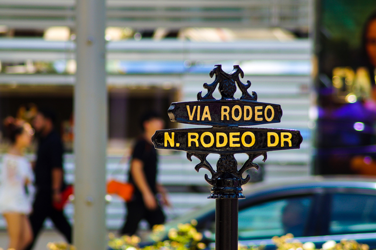 Ein schwarzes Eisenschild mit gelber Aufschrift Rodeo Drive heißt die Besucher in Los Angeles Willkommen.