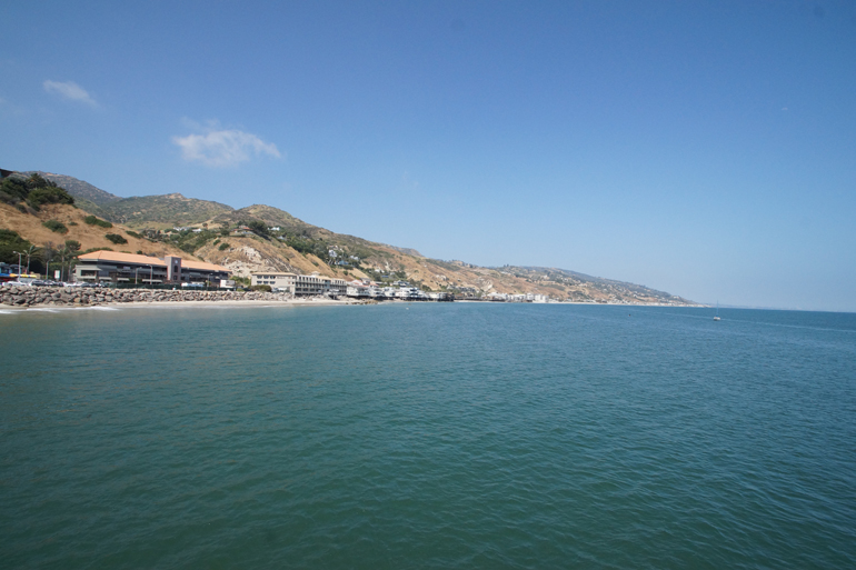 Eine Bucht in Malibu, Los Angeles -USA, mit Strand und blauem Wasser.
