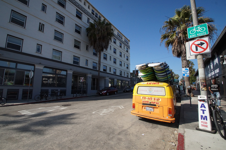Ein gelber Bus in Los Angeles mit Surfbrettern auf dem Dach.
