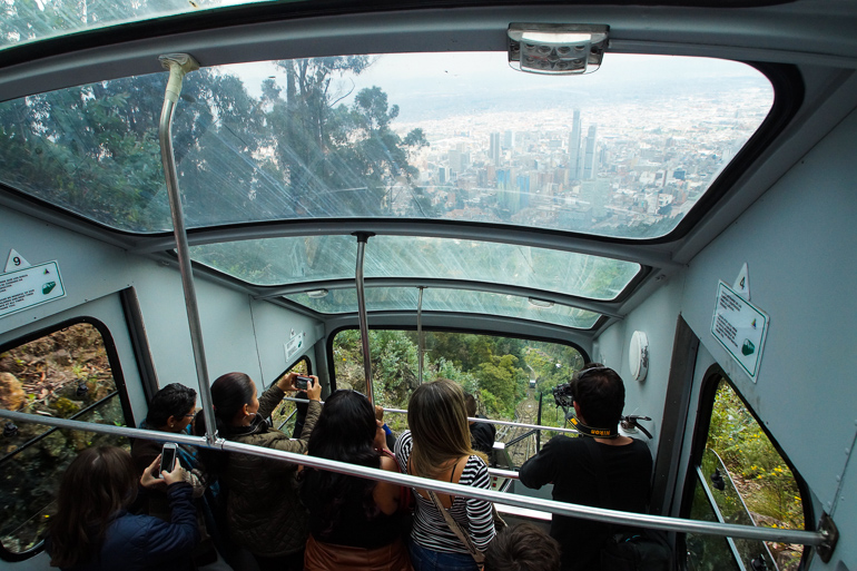 Tourists photograph the view of Bogotá in a gondola on the way to Mount Monserrate in Colombia.