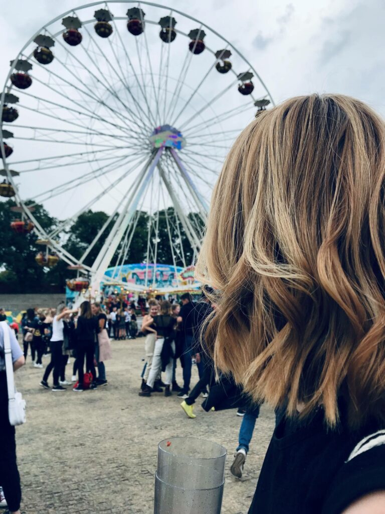 Eine Frau blickt auf dem Lollapalooza Festival in Berlin auf ein Riesenrad.