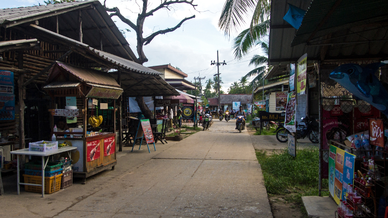 Auf einer kleinen Straße durch das Dorf von Koh Mook befinden sich zahlreiche kleine Shops und Restaurants, die Einheimischen sind auf dieser Straße überwiegend mit Rollern und Motorrädern unterwegs.
