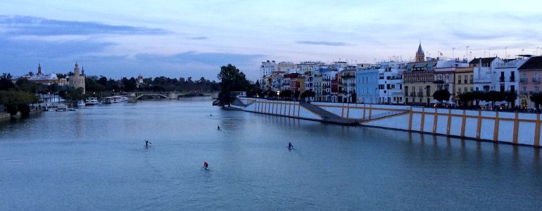 Eine wunderschöne Aussicht auf den Guadalquivir mit Häusern an der Wasserfront.
