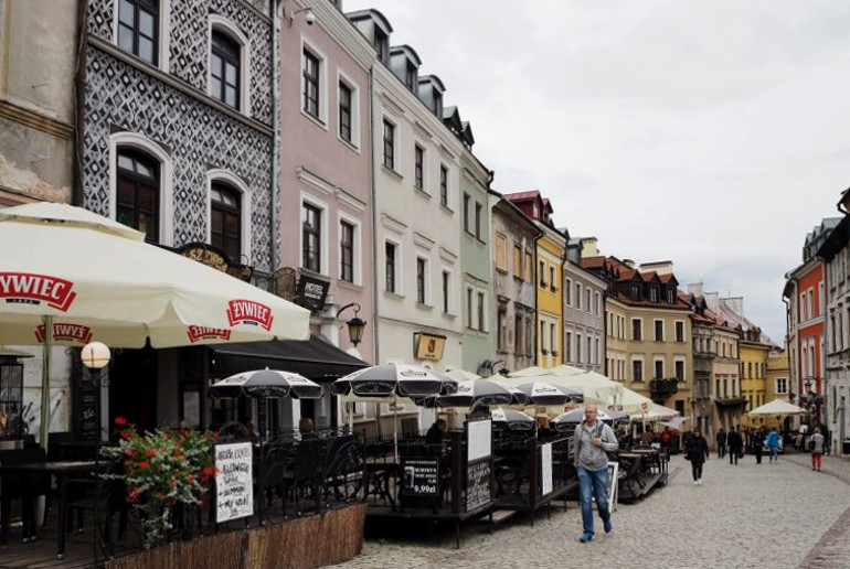 In der Altstadt von Lublin sind entlang der Fußgängerzone ein Restaurant oder Cafe nach dem anderen gereiht, in den kleinen Gastgärten wurden Sonnenschirme gespannt.